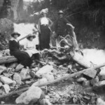 Local La Plata City residents, Unknown, Elvira Ekburg, Mary Ekburg, and Gus Ekburg, standing next to Bourn Creek after flooding.